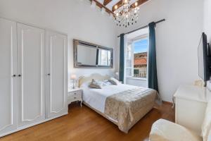 a white bedroom with a bed and a window at Palmotta Palace in Dubrovnik