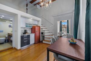 a kitchen and dining room with a table and a kitchen and a staircase at Palmotta Palace in Dubrovnik