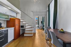 a kitchen and dining room with a table and a staircase at Palmotta Palace in Dubrovnik