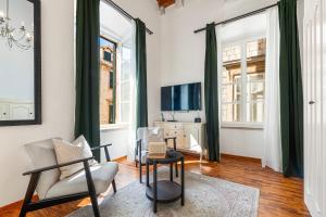 a living room with two chairs and a tv at Palmotta Palace in Dubrovnik