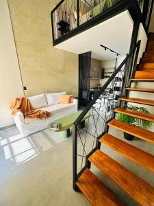 a living room with a couch and a staircase at LOFTIER COSTANERA Depto 402 in Posadas