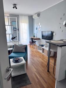Una sala de estar con un sofá azul y una mesa. en Marse Stay, en Belgrado