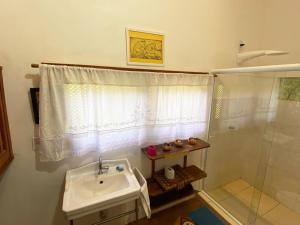 a bathroom with a sink and a shower at Casa nos Algodoes, imersa na natureza in Marau