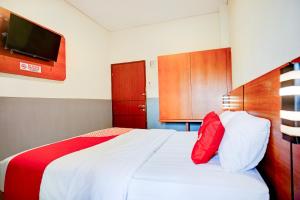 a bedroom with a white bed with red pillows at Dancenter Sean'S Residence Mansyur Near Universitas Sumatra Utara USU in Polonia Airport