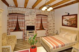 a bedroom with a bed and a stone wall at Apartments Parteli in Kotor