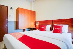 a bedroom with a large bed with red pillows at Dancenter Sean'S Residence Mansyur Near Universitas Sumatra Utara USU in Polonia Airport