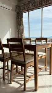 una mesa de madera y sillas con ventana en Azul Horizonte with a pool, en Benalmádena