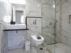 a bathroom with a toilet and a shower and a sink at Golden Olive Apartment in Kardamaina