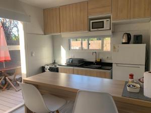 a kitchen with a wooden counter with chairs in it at Vista24uy Ref1002 in Maldonado