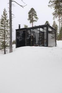 a glass house in the snow at Norlight Cottages Ivalo - Aurinko East in Ivalo
