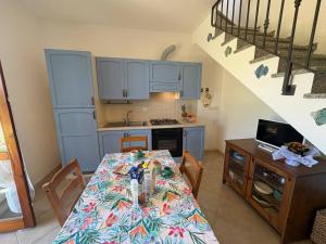 a kitchen with a table and a kitchen with a staircase at AffittaSardegna - Casa Girasole in La Ciaccia