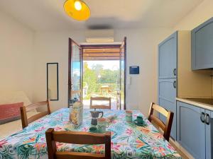 a dining room with a table and a kitchen at AffittaSardegna - Casa Girasole in La Ciaccia