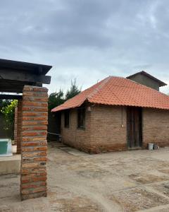 een stenen huis met een bakstenen pilaar ervoor bij Chalé Magia in Luis Correia