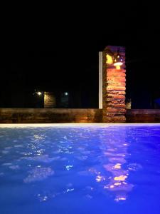 een stenen pilaar met een klok in een vijver 's nachts bij Chalé Magia in Luis Correia +4 foto's