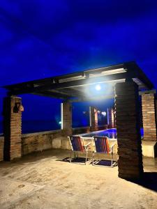 een patio met 2 stoelen en 's avonds een tafel bij Chalé Magia in Luis Correia