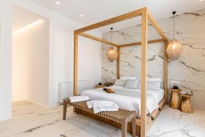 a bedroom with a canopy bed with a wooden frame at Elaia Home luxury village apartment for two Naxos in Galini