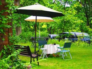a table and chairs under an umbrella in a yard at Snowfall Meteor 飛雪流星 in Kaminoyama