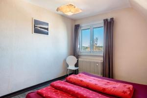 Un dormitorio con una cama con sábanas rojas y una ventana. en Blackforest Ferienwohnung, en St. Georgen im Schwarzwald