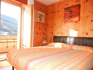 1 dormitorio con cama y ventana grande en Casa Elda, en Valdidentro