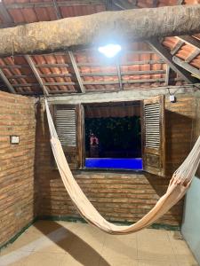 een lege kamer met een hangmat in een gebouw bij Chalé Magia in Luis Correia