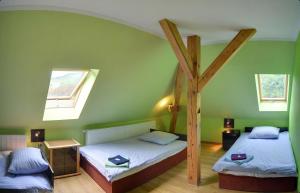 two twin beds in a green room with skylights at Gościniec Rudawski in Kamienna Góra