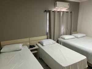 Postel nebo postele na pokoji v ubytování Hotel Parati Arapongas