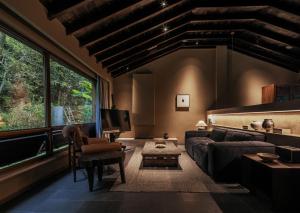 uma sala de estar com um sofá e uma TV em 景德镇行山世外东篱院民宿 em Xianghu
