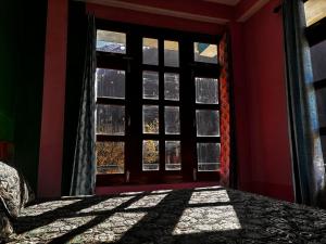 a room with a window with a bed and a view at Snow View Guest House in Kulu +2 photos