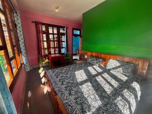 a bedroom with a bed with a green wall at Snow View Guest House in Kulu