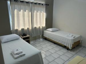 Postel nebo postele na pokoji v ubytování Hotel Parati Arapongas