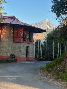 a brick house with a mountain in the background at Karma homestay in Ravangla