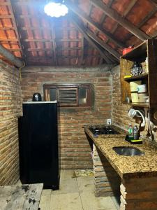 een keuken met een zwarte koelkast en een spoelbak bij Chalé Magia in Luis Correia