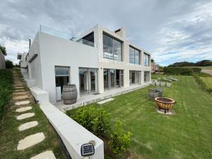 a large white house with a large yard at Huis Marais Oubaai Golf Estate in Herolds Bay