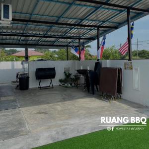 a covered patio with a table and a piano at Homestey de Usraty in Kampung Sungai Baharu