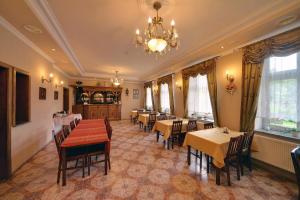 a dining room with tables and chairs and a chandelier at Gościniec Rudawski in Kamienna Góra