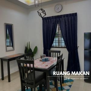 a dining room table and chairs with a clock on the wall at Homestey de Usraty in Kampung Sungai Baharu