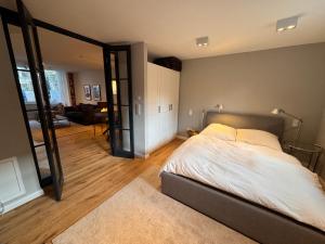 a bedroom with a bed and a living room at Neue 2 Zimmer Wohnung im Grünen mit Terrasse und Platz in Kleinmachnow