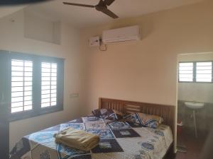 a bedroom with a bed and a ceiling fan at Thiru Somasundaram in Tiruvannāmalai +27 photos