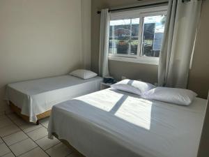 Postel nebo postele na pokoji v ubytování Hotel Parati Arapongas