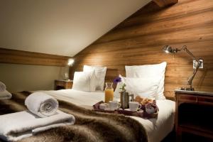 a hotel room with a bed with a tray of food on it at Chamois d'Or Hotel in Les Gets +58 photos