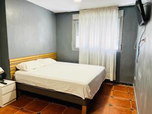 a bedroom with a bed and a window at Hospedaje Ronda de Poniente in Torrejón de Ardoz +52 photos
