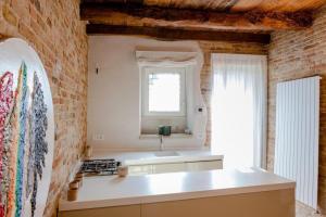 una cucina con un lavello e un muro di mattoni di Medieval Tower With Views Of Sibillini Mountains a Magliano di Tenna