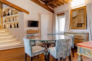 una sala da pranzo con un tavolo di vetro e sedie blu di Medieval Tower With Views Of Sibillini Mountains a Magliano di Tenna
