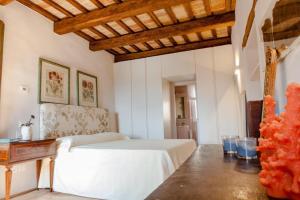 una camera da letto con un letto bianco e un soffitto in legno di Medieval Tower With Views Of Sibillini Mountains a Magliano di Tenna