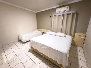 Postel nebo postele na pokoji v ubytování Hotel Parati Arapongas