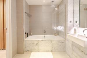 a bathroom with a tub and a sink at Luxe 2 Bed Apartment in heart of Soho in London +10 photos