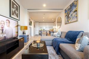 a living room with a couch and a tv at Luxe 2 Bed Apartment in heart of Soho in London