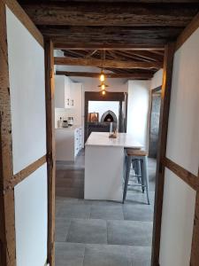 eine Küche mit weißen Wänden und einem Tisch in einem Raum in der Unterkunft Casa and Company - Azorean Boutique House in Santa Cruz da Graciosa