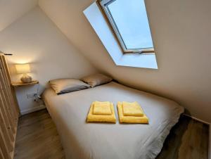 a bedroom with a bed with two yellow towels on it at Ibiza- l'escapade a saint Brieuc in Saint-Brieuc