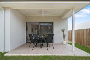 a patio with a table and chairs on it at The Crest North Harbour Estate Sleeps 8 in Burpengary East